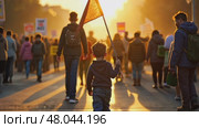 A child holding a small black flag, standing in a crowded street at sunset, the golden light casting long shadows as people march. Стоковое AI-видео, аниматор Sergey Grishin / Фотобанк Лори