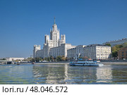 Высотное здание на Котельнической набережной в Москве, Россия. Прогулочный теплоход плывет по Москве-реке (2024 год). Редакционное фото, фотограф Елена Коромыслова / Фотобанк Лори