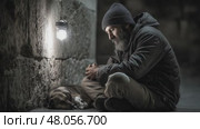 Homeless man praying with his dog under a street lamp. Стоковое AI-видео, аниматор Юрий Поздников / Фотобанк Лори