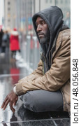 Homeless man sitting on wet pavement in city. Стоковое AI-видео, аниматор Юрий Поздников / Фотобанк Лори