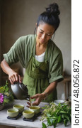 Woman pouring tea into small green teacups. Стоковое AI-видео, аниматор Юрий Поздников / Фотобанк Лори