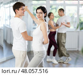 Girl paired up with young man, they train to perform hustle dance, rehearse performance. Стоковое фото, фотограф Яков Филимонов / Фотобанк Лори