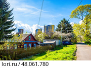 Деревенский дом на фоне современной многоэтажки. Редакционное фото, фотограф Илья Старков / Фотобанк Лори