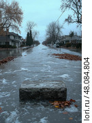 A street is completely flooded with water covering sidewalks and accumulating leaves, creating a tranquil yet eerie atmosphere. Стоковое AI-изображение, AI-художник Данила Большаков / Фотобанк Лори