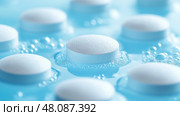 Close-up view of light blue effervescent tablets in water bubbles. Крупный план светло-голубых шипучих таблеток в пузырьках воды. Стоковое AI-изображение, AI-художник Katsiaryna Repich / Фотобанк Лори