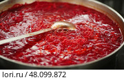 A detailed close up view of simmering beetroot soup, highlighting its rich, vibrant red color and unique texture. Стоковое фото, фотограф David Kashakhi / Фотобанк Лори