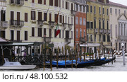 Gondolas docked on grand canal with italian flag waving. Стоковое фото, фотограф David Kashakhi / Фотобанк Лори