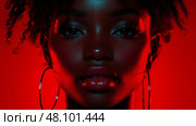 A woman stands confidently with defined facial features, highlighted by vibrant red lighting, showcasing her natural beauty and style. Стоковое AI-изображение, AI-художник Данила Большаков / Фотобанк Лори