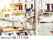 Sailboat mast with ropes in bustling marina on sunny day, background. Стоковое фото, фотограф Анастасия Золотницкая / Фотобанк Лори