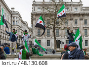 Activists holding Syrian independence flags at public demonstration. London, UK, 16 March 2024. Редакционное фото, фотограф Zydrius Tartenis / Фотобанк Лори