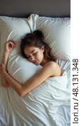 Young Woman Peacefully Sleeps in Bed With a Soft Pillow and Fresh Linens, Embodying Wellness and Restful Sleep. Стоковое AI-изображение, AI-художник Sergey Grishin / Фотобанк Лори