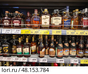 Витрина с бутылками крепкого алкоголя в магазине. Редакционное фото, фотограф Мария Сергеева / Фотобанк Лори