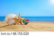 Beautiful beach in South Africa. Flag of South Africa in the shape of a heart and shells on a sandy beach. (2021 год). Стоковое фото, фотограф Никита Бурденков / Фотобанк Лори