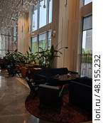 Уютный интерьер кафе с панорамными окнами и зелеными растениями. Radisson Blu Leninsky Prospect Hotel. Редакционное фото, фотограф Мария Сергеева / Фотобанк Лори