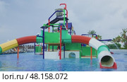 A Vibrantly Colorful Water Play Structure Featuring Exciting Slides Inside a Pool Area. Стоковое видео, видеограф Olesia Kondrateva / Фотобанк Лори