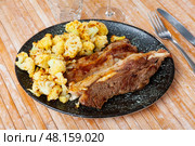 Lunch for restaurant guest - fried fatty and juicy lamb and vegetable side dish of cauliflower. Стоковое фото, фотограф Яков Филимонов / Фотобанк Лори