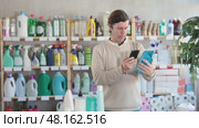 Man uses barcode to get information about glass cleaner spray in mobile application. Стоковое видео, видеограф Яков Филимонов / Фотобанк Лори