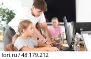 Guy teacher teaches girl student how to use computer. Стоковое видео, видеограф Яков Филимонов / Фотобанк Лори
