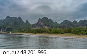 A picturesque calm river. Ripples on the surface of the water. There is green vegetation on the shore. Beautiful mountains against the sky and clouds. China. Li River. Li Jiang. Guilin. Стоковое фото, фотограф Вера Ивановна Кубарева / Фотобанк Лори