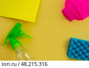 Cleaning. Flat lay Bottles with cleaning product and sponges on a yellow background, empty space in the center. Стоковое фото, фотограф Юлия Николаева / Фотобанк Лори