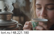 A woman is drinking coffee from a cup while wearing a colorful scarf. Стоковое AI-видео, аниматор Виктория Кольцова / Фотобанк Лори