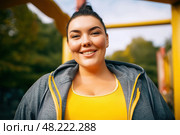 Happy plus size fat woman in tracksuit outdoors. Стоковое AI-изображение, AI-художник Станислав Тарко / Фотобанк Лори