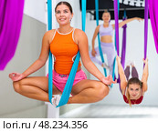 Girl doing Baddha Konasana asana in suspended hammock with hands in mudra. Стоковое фото, фотограф Яков Филимонов / Фотобанк Лори