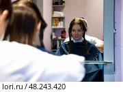 Woman Experiences a Transformative Moment at the Hair Salon While Getting Her Hair Styled. Стоковое фото, фотограф Aleksandr Golubev / Фотобанк Лори