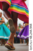 A close-up of a dancer's feet in traditional Mexican huaraches, mid-step during a folkloric dance performance. The vibrant skirt waving on air. Стоковое AI-видео, аниматор Sergey Grishin / Фотобанк Лори