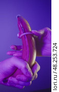 A couple puts a condom on a banana, symbolizing the penis before engaging in sexual intercourse. Close up. Studio shot. Стоковое видео, видеограф Strunov David / Фотобанк Лори