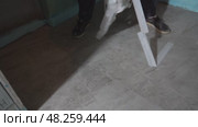 Grouting of joints between ceramic tiles. Cleaning after renovation. Construction. The adhesive tape is removed from the floor. Стоковое видео, видеограф Darya Komarova / Фотобанк Лори
