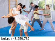 Preteen girl performing elbow and knee strikes while blocking arm of boy in mock fight. Стоковое фото, фотограф Яков Филимонов / Фотобанк Лори