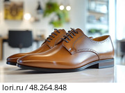 Elegant brown leather dress shoes on display in a modern office setting. Стоковое AI-изображение, AI-художник Юрий Поздников / Фотобанк Лори