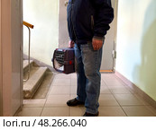 An elderly man holds a cat in a carrier. Pet transportation. Стоковое фото, фотограф Терехова Марина / Фотобанк Лори