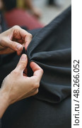A close-up of a woman's hands sewing a black cloth banner, her fingers trembling slightly as she prepares for the Ashura process. Стоковое AI-видео, аниматор Sergey Grishin / Фотобанк Лори