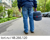 An elderly man holds a cat in a carrier. Pet transportation, traveling with a pet. A close friend of an elderly man. Стоковое фото, фотограф Терехова Марина / Фотобанк Лори