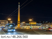 Площадь Восстания, Санкт-Петербург, Россия. Вид на стелу «Город-герой Ленинград» и павильон станции Петербургского метрополитена «Площадь Восстания». Троллейбусы и автомобили на проезжей части. Красивый вечерний городской пейзаж. Ночной город. (2023 год). Редакционное фото, фотограф Андрей Степанов / Фотобанк Лори