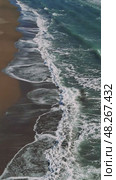 Turquoise ocean waters generating white foam, gentle waves cascading over pristine sandy shore under bright sunlight, revealing tranquil tropical seascape. Стоковое видео, видеограф ILIA GOROKHOV / Фотобанк Лори