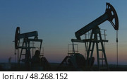 Working oil pumps silhouette in dusk, 4k. Стоковое видео, видеограф Михаил Коханчиков / Фотобанк Лори