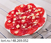 Thinly sliced beef carpaccio with Parmesan for appetizer. Стоковое фото, фотограф Яков Филимонов / Фотобанк Лори
