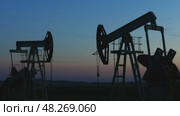 Working oil pumps silhouette in dusk, 4k. Стоковое видео, видеограф Михаил Коханчиков / Фотобанк Лори