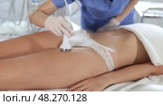 Young woman undergoing phonophoresis procedure on anterior thighs using high-frequency ultrasound attachment in cosmetic clinic. Modern hardware cosmetology. Стоковое видео, видеограф Яков Филимонов / Фотобанк Лори