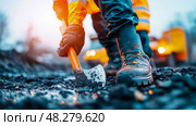 Groundwork Concept: Manual labor digging in dirt and mud, construction site with worker in uniform at dusk. Стоковое AI-изображение, AI-художник Данила Большаков / Фотобанк Лори