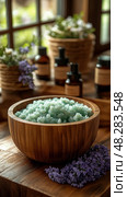 Spa Day Still Life: A wooden bowl of soothing green bath salts, aromatherapy oils, and calming lavender for relaxation. Стоковое AI-изображение, AI-художник Данила Большаков / Фотобанк Лори