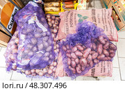 Свежий египетский картофель, упакованный в мешки, продается в продуктовом магазине. Редакционное фото, фотограф FotograFF / Фотобанк Лори