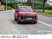 Chery Tiggo 4 car in motion. Red chinese SUV on urban road, front side view. Редакционное фото, фотограф Константин Григорьев / Фотобанк Лори