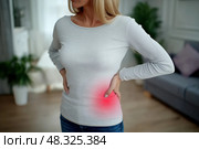 Pain in left side, kidney inflammation, woman suffering from backache at home. Стоковое AI-изображение, AI-художник Станислав Тарко / Фотобанк Лори