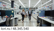 Young man and woman walk across a scientific office. Intentional motion blur. LED lighting create shadow-free illumination. Стоковое AI-изображение, AI-художник Катерина Ковалева / Фотобанк Лори