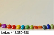 Row of colorful candies are lined up on a white background. Стоковое AI-видео, аниматор Sergey Grishin / Фотобанк Лори