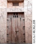 Dubai, UAE - March 4, 2025: Wooden door in the Old City district in Dubai. Редакционное фото, фотограф Оксана Чаюн / Фотобанк Лори